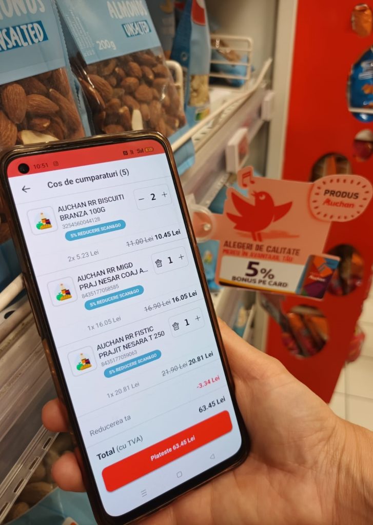 Smartphone mit Auchan Romania App und Scan & Go Warenkorb.